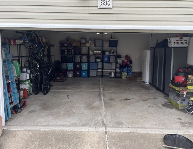 Garage in Charlotte, NC, after Haulchemy's garage cleanout and organization service, showing open floor space and household items arranged on shelves.