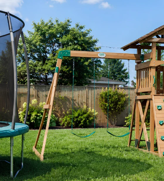 Playset & Trampoline Removal: a wooden playset with a slide and a trampoline in a back yard